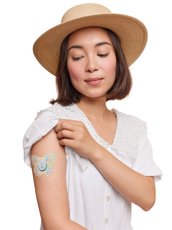 Dexcom G7 butterfly shape patch worn on a woman’s arm, with breathable adhesive fabric for sensor support