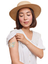 FreeStyle Libre 3 butterfly shape patch worn on a woman’s arm, with breathable adhesive fabric for sensor support