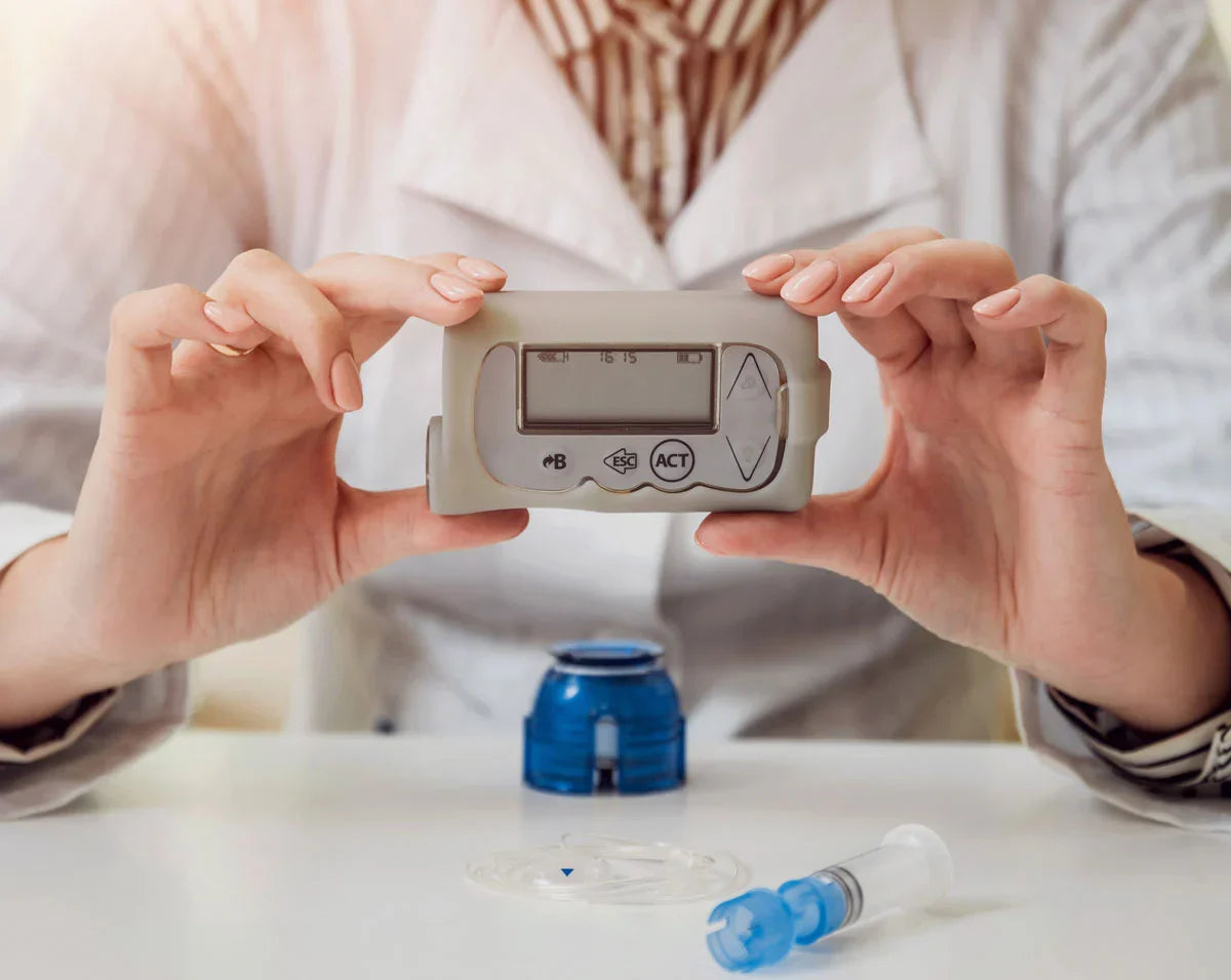 person holding blood glucose meter device with insulin pump components showing diabetes device maintenance and usage Immagine