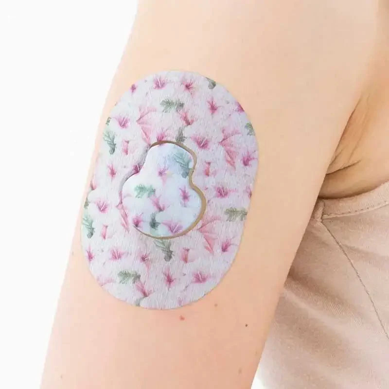 Guardian Enlite Sensor Patches worn on arm, featuring a pink and green floral design for daily use and protection. Immagine