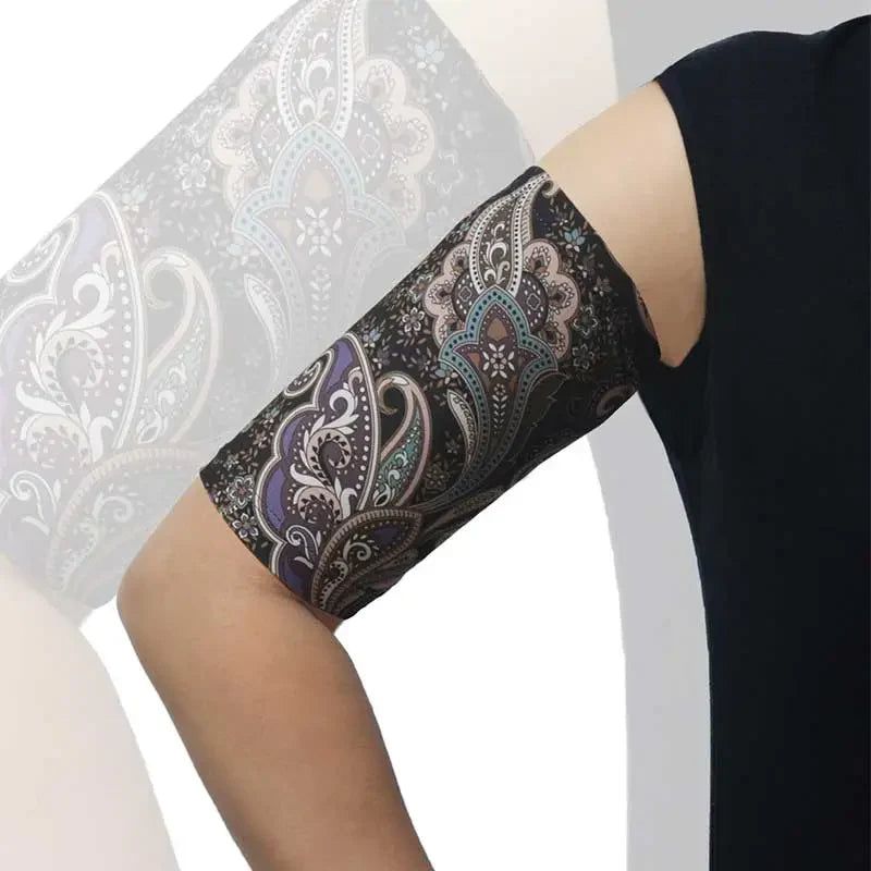 PICC line arm sleeve with a black background and colorful paisley pattern, worn on an arm for comfortable, protective daily use. Immagine