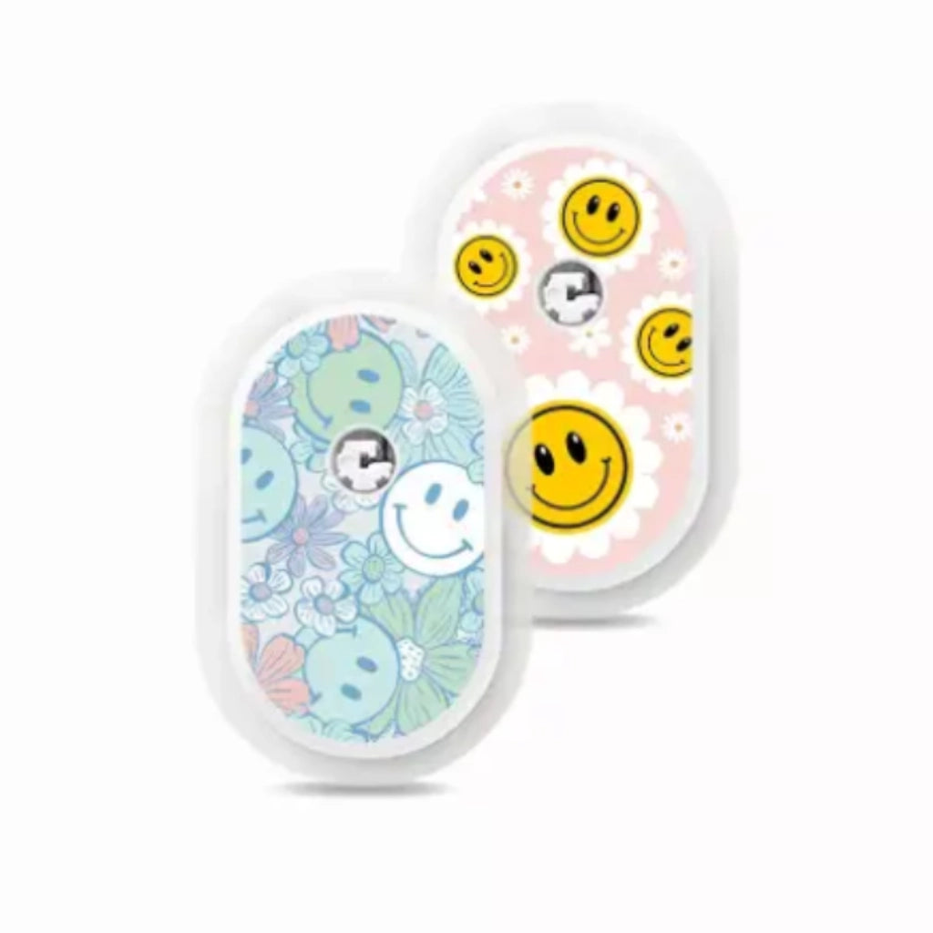 Sibionics GS1 CGM devices with colorful vinyl stickers, featuring smiley faces and floral designs. Immagine