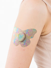 Cerotto adesivo per Dexcom G7, forma farfalla, sul braccio, primo piano