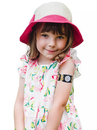 Child wearing Dia-Style Kiddy Libre 2 Armband with floral dress and hat.