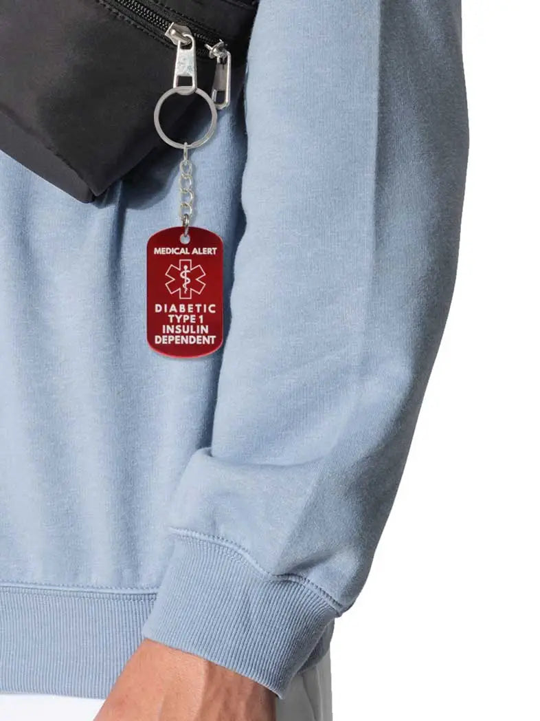 Diabetic Type 1 insulin dependent metal keychain with red medical alert symbol hanging from a bag zipper.